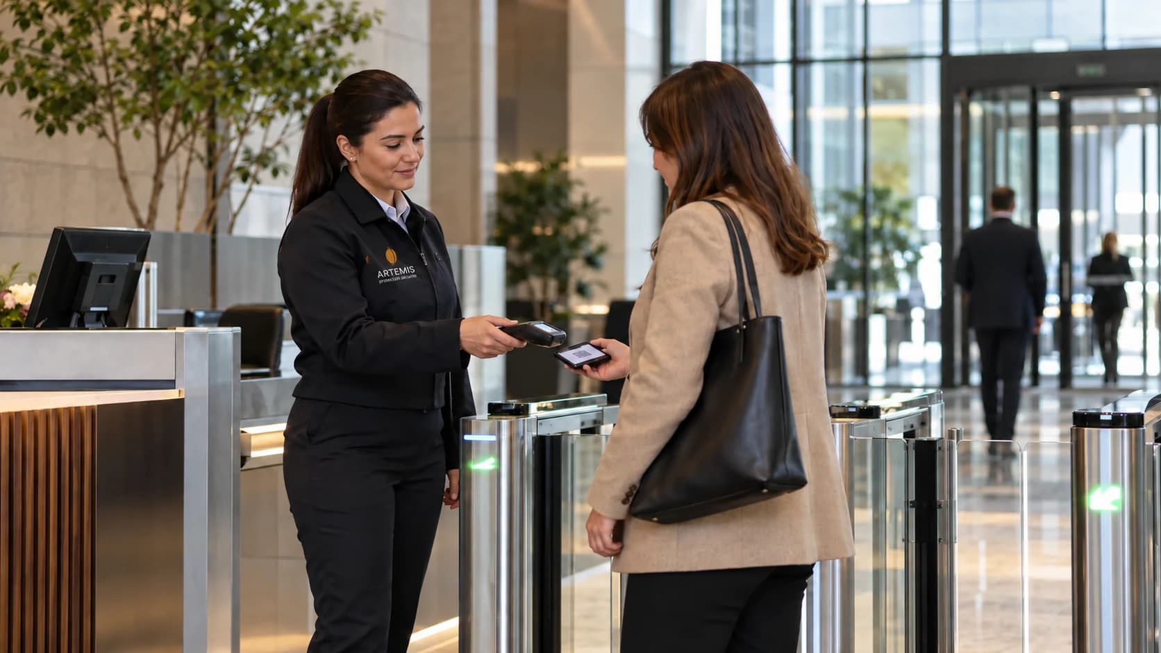 Une agente contrôle l'accès à un bâtiment professionnel auprès d'une visiteuse