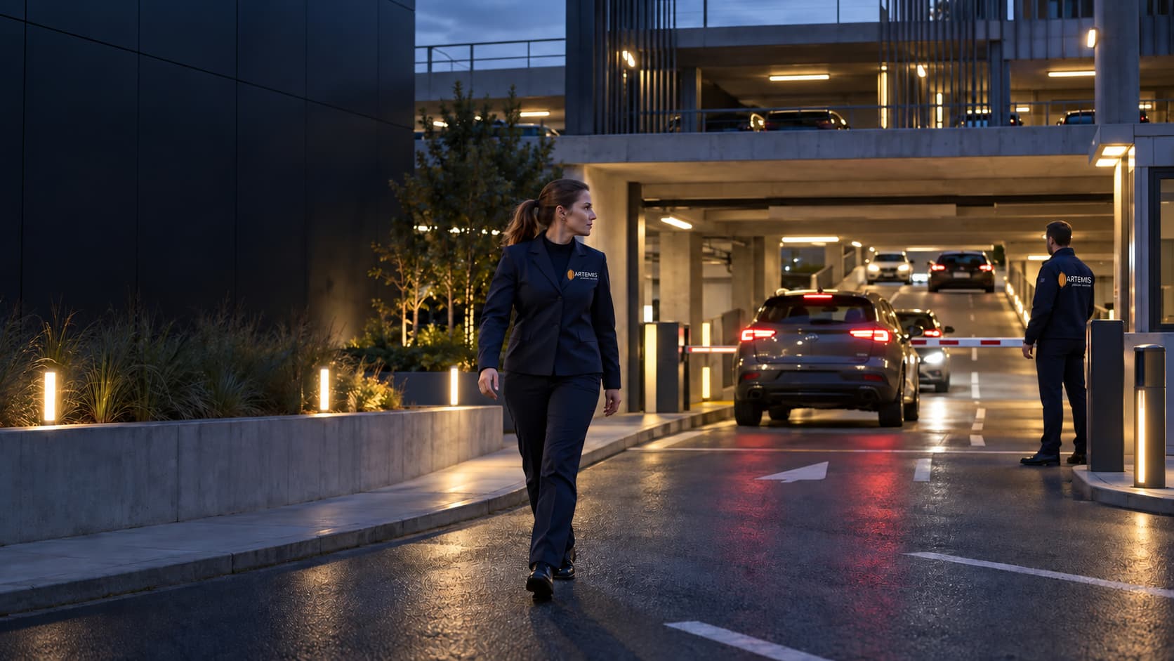 Une agente surveille l’entrée d’un parking à la tombée du jour